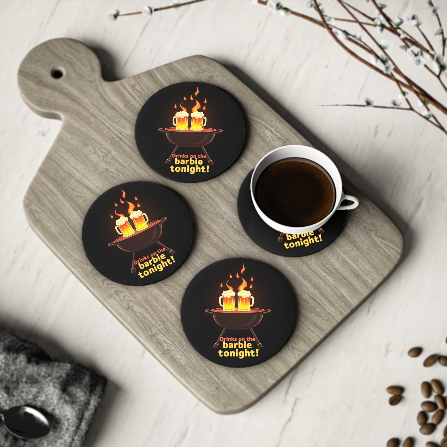 Set of 4 round black coasters with BBQ and beer mug design, reads Drinks on the barbie tonight, on timber board