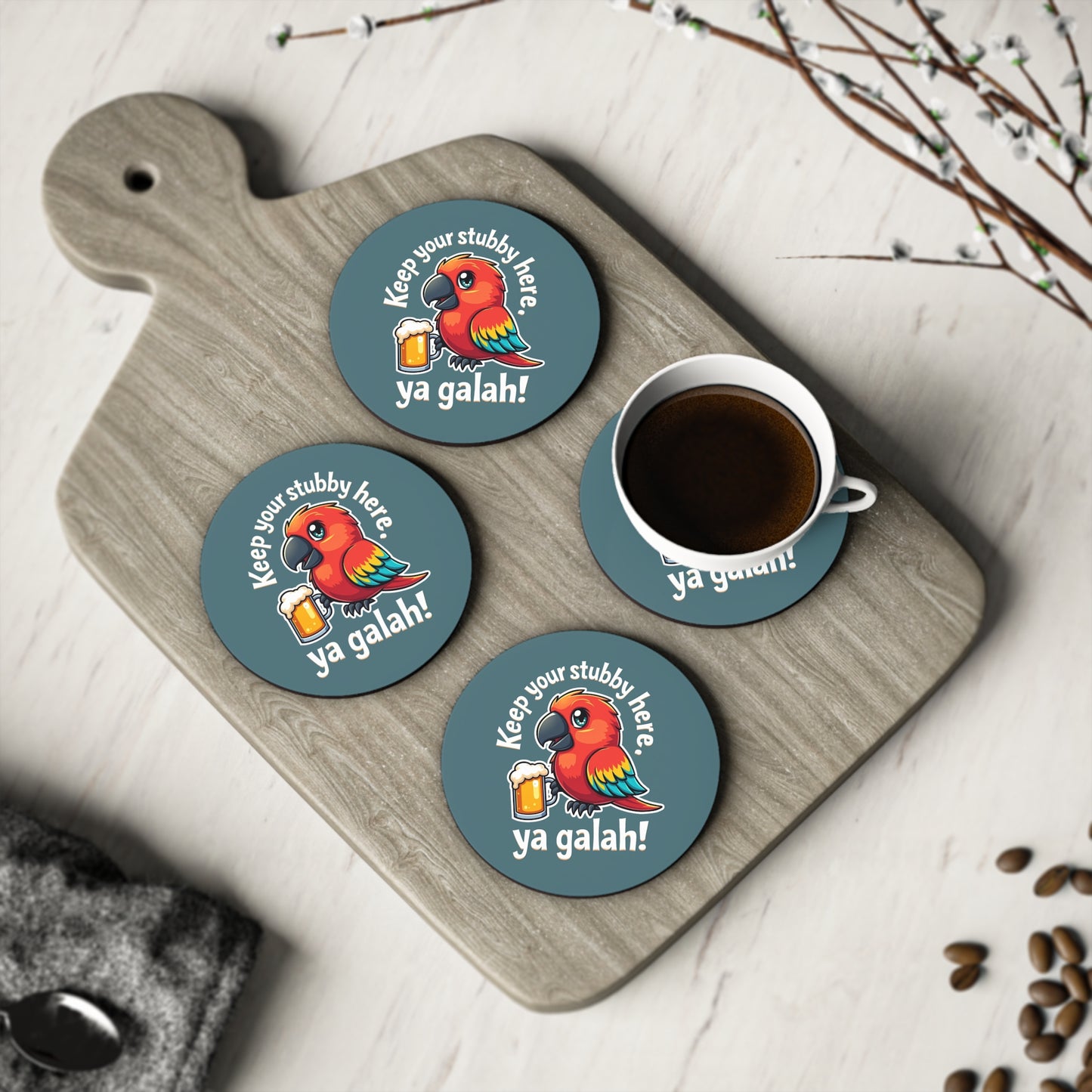 Set of 4 round teal coasters with cartoon galah holding beer, "Keep your stubby here, ya galah!" on timber board