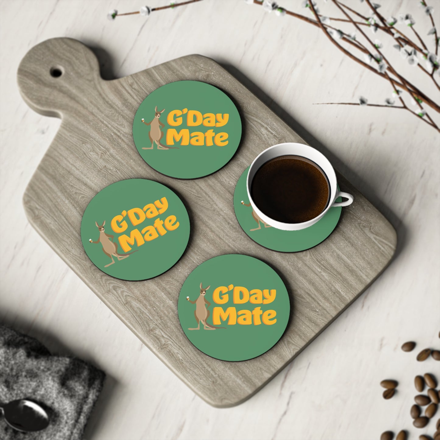G'Day Mate Coasters set of four, green round coasters with kangaroo design, shown with coffee cup on timber board
