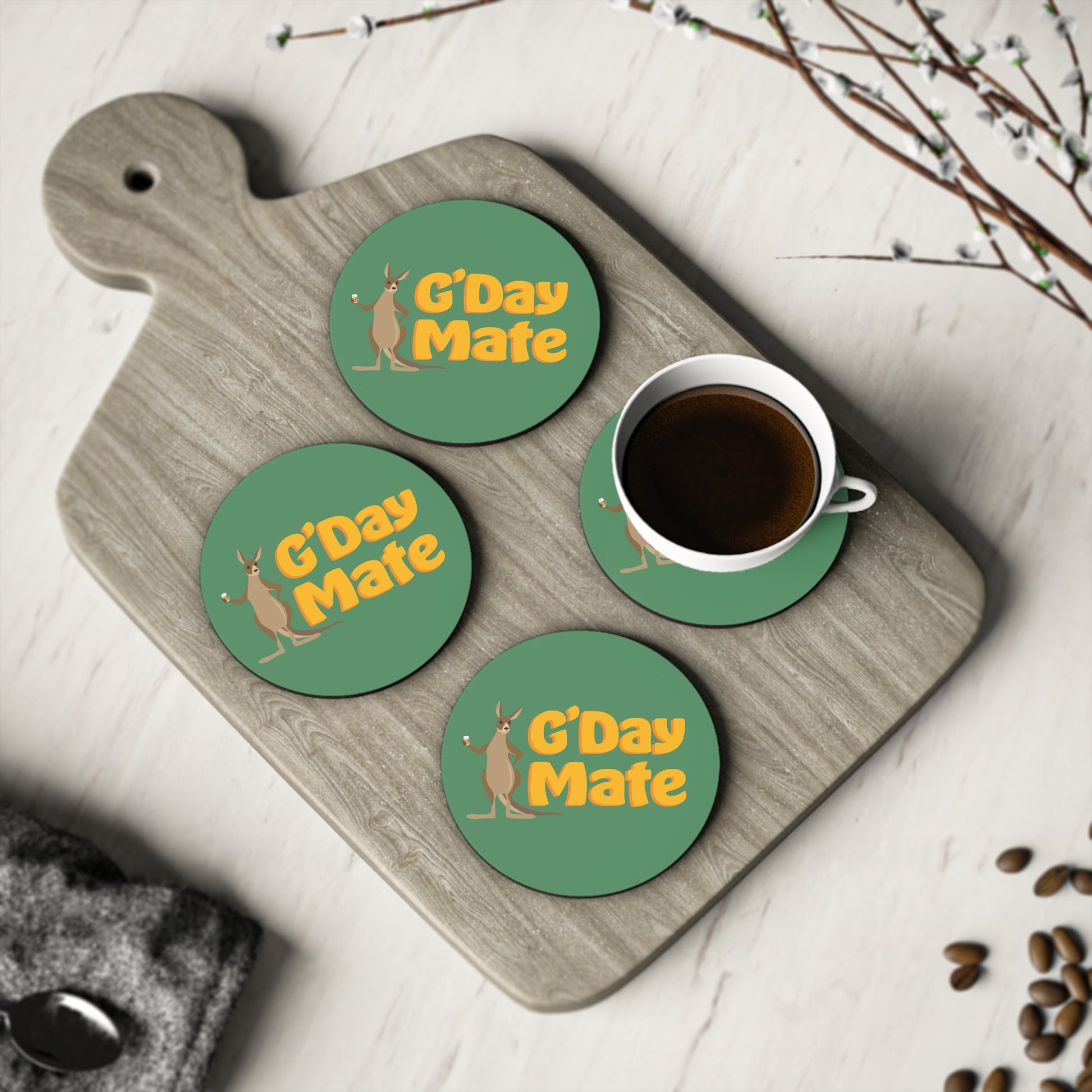 G'Day Mate Coasters set of four, green round coasters with kangaroo design, shown with coffee cup on timber board